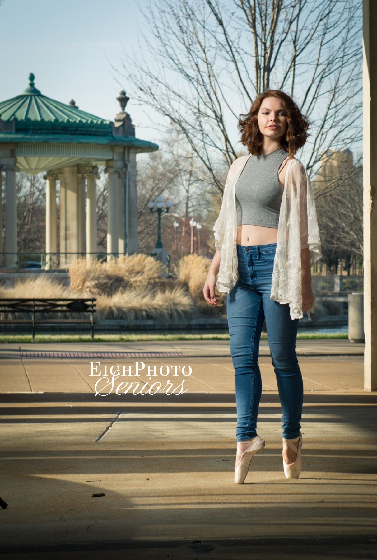 Effortless Ballet Dance Pose in Pointe Shoes, blue jeans, crop top, and a lace duster at the Muny Senior Portraits in Forest Park. Senior Photographers in St. Louis